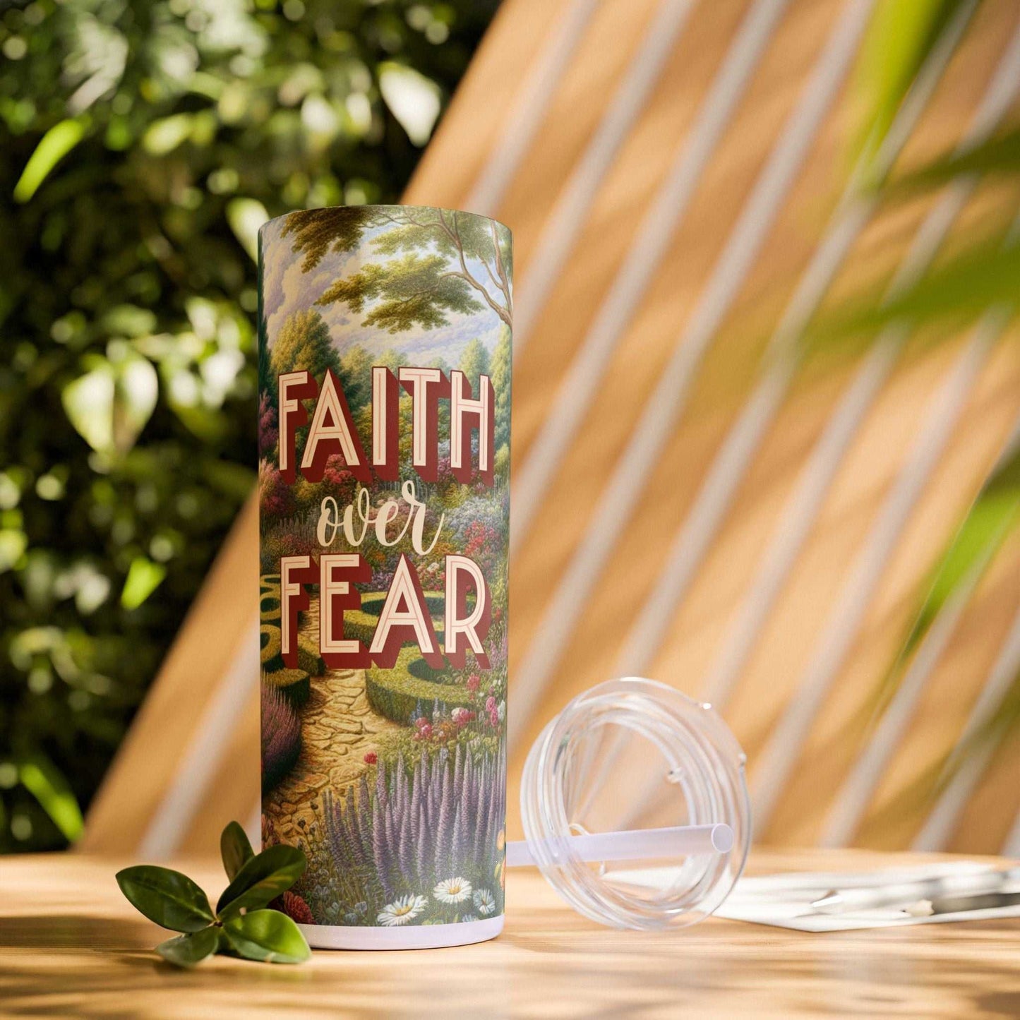 20 oz skinny tumbler with straw featuring "Faith Over Fear" design, double-wall, BPA-free, keeps drinks hot or cold, stainless steel and plastic materials.