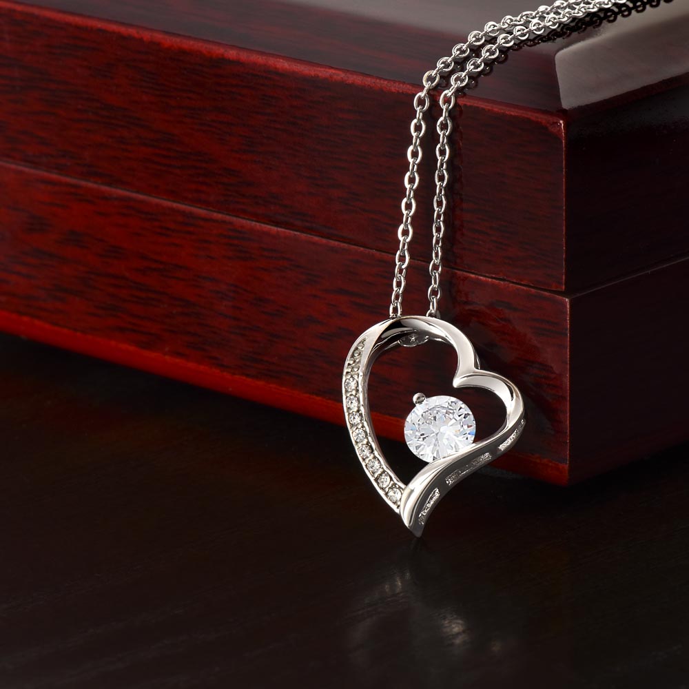 Heart-shaped Forever Love Necklace with CZ crystal on wooden box.