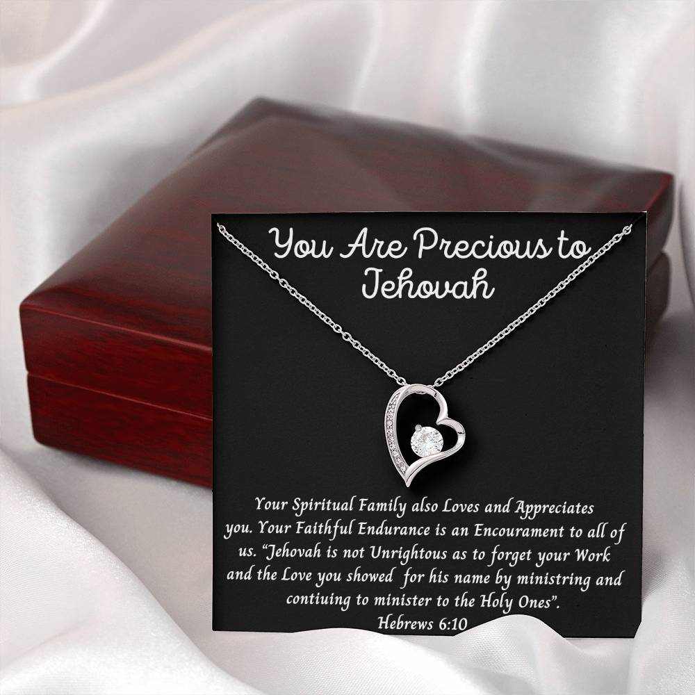 Heart-shaped necklace with "You Are Precious to Jehovah" inscription, featuring a CZ crystal and heart pendant in white or yellow gold finish, displayed in a gift box.