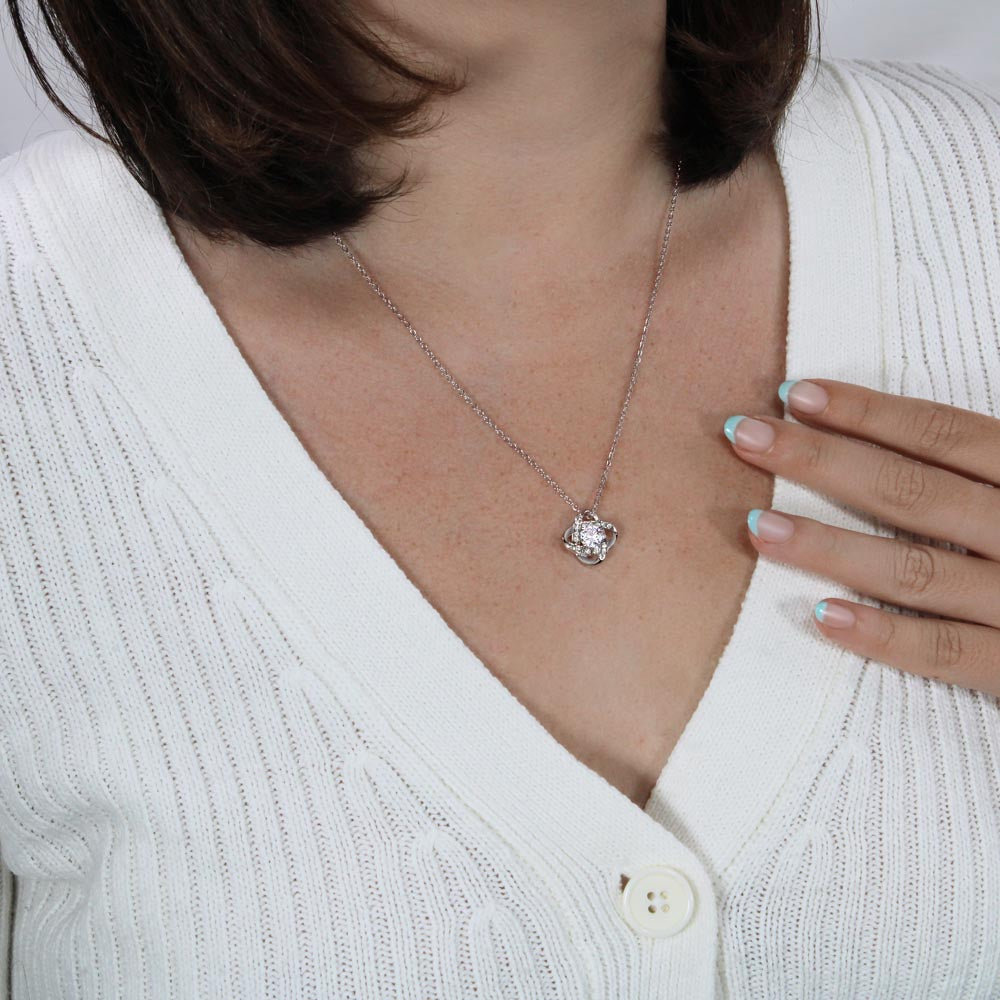 Woman wearing Love Knot Necklace with cubic zirconia pendant.