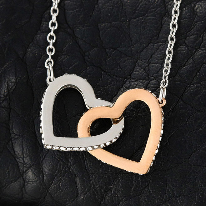 Interlocking hearts necklace with CZ crystals in surgical steel and rose gold finish.