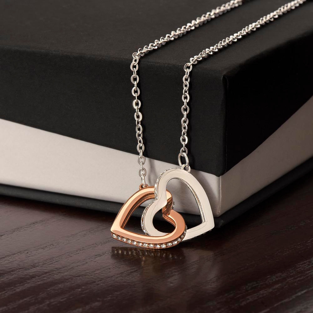 Interlocking hearts necklace with cubic zirconia gems on a gift box.