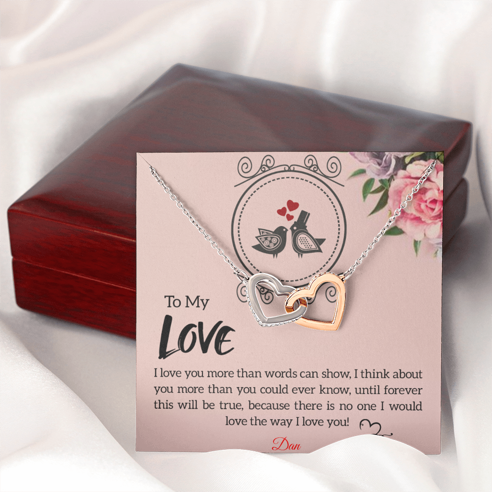 Necklace with interlocking hearts and personalized message card displayed on a luxury box.