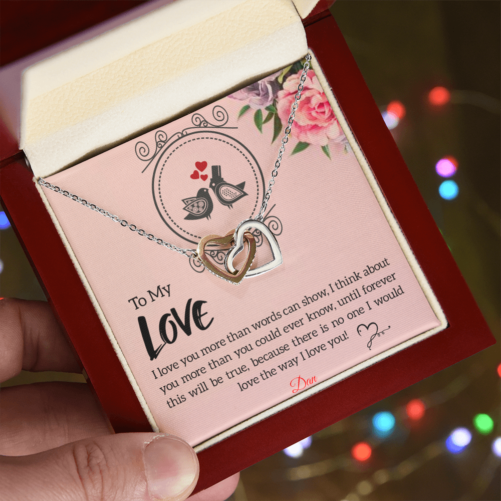 Interlocking hearts necklace with personalized message card on display in gift box.