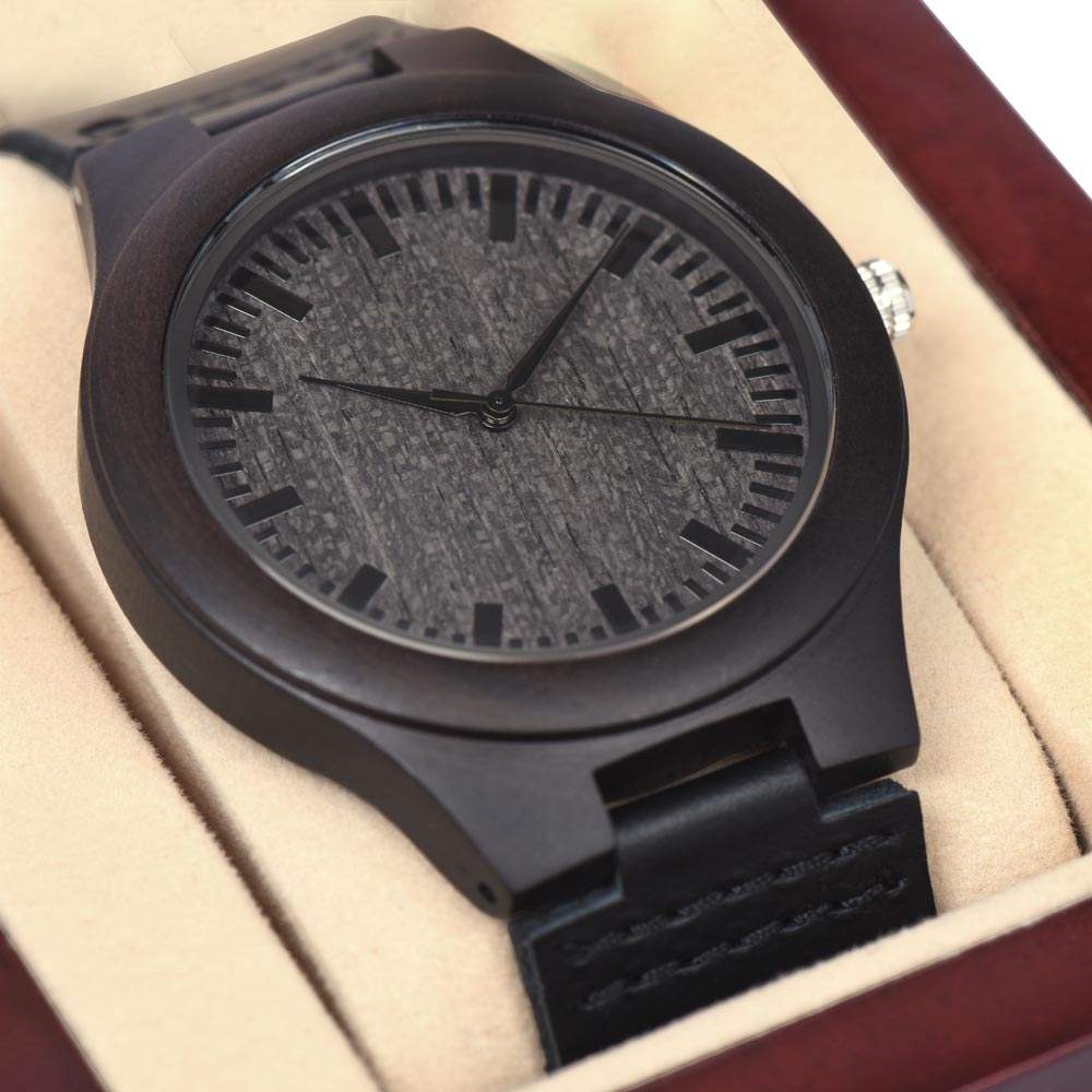 Man's wooden watch with sandalwood casing and black leather strap in a gift box.