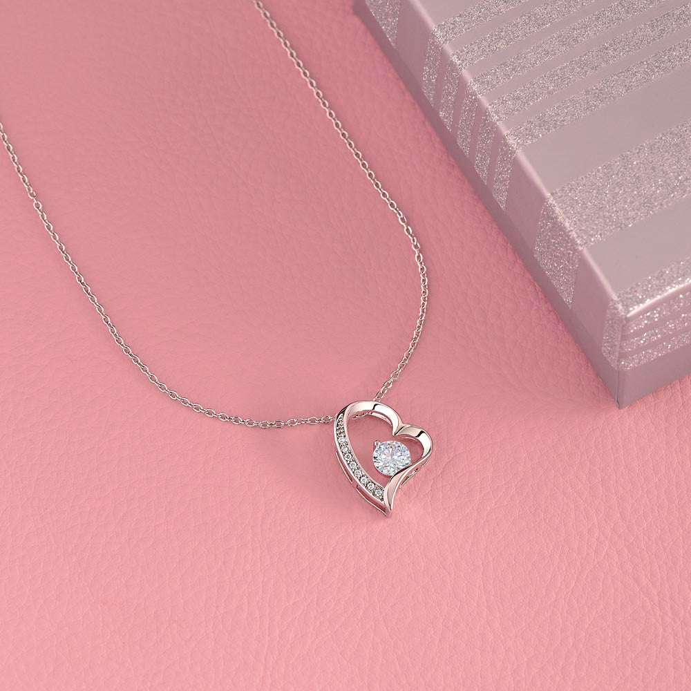 Forever Love heart necklace with CZ crystal for sister on pink background.