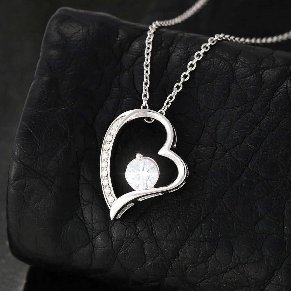 Heart-shaped necklace with central CZ crystal, 14k white gold finish, on black background.