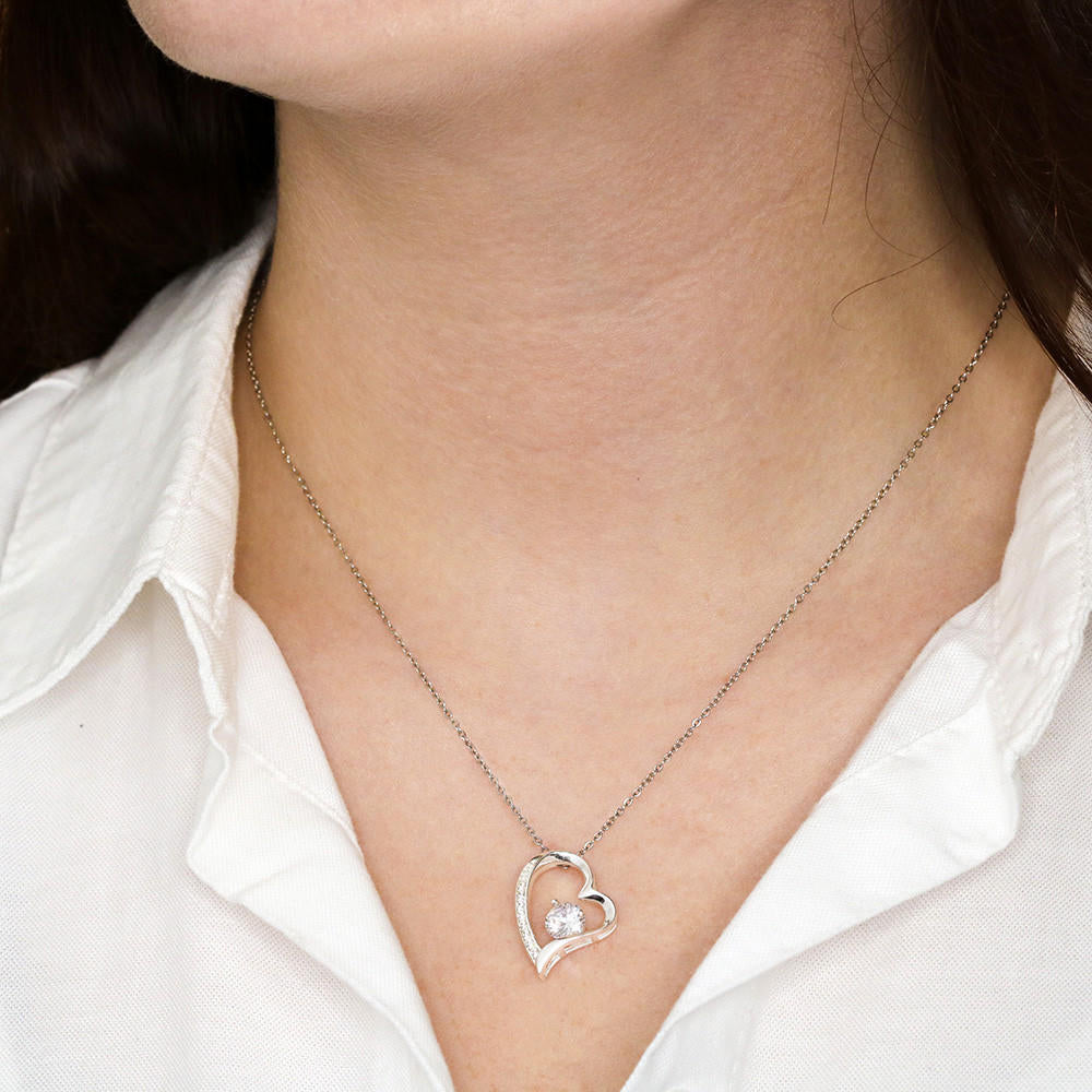 Heart-shaped necklace with CZ crystal on model, featuring adjustable chain and gold finish options.